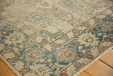 Distressed vintage Tabriz corner showing aqua blue palmettes, ivory field, and subtle blush.