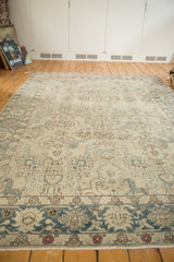 Aqua blue border featuring palmettes, framing the distressed ivory field with blush floral blossoms.