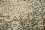 Distressed Tabriz rug corner with aqua border, ivory field, and worn palmette patterns.