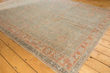 Sivas carpet corner showing dusty sea foam green, terracotta palmette border.
