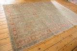 Distressed vintage Sivas rug corner with terracotta and dusty green border, faded lotus, palmette motifs.