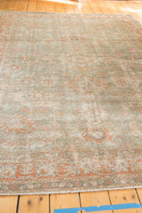 Distressed Sivas carpet showing even wear, dusty seafoam green field, terracotta palmette motifs.