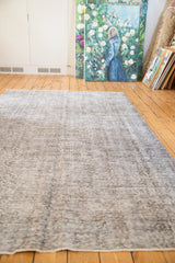 Fully secured end of the distressed Sparta carpet, with time-softened silver and charcoal hues.