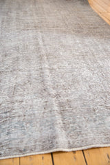 Close-up of a distressed vintage Sparta carpet, showing low pile, subtle floral design, in silver and slate blue.