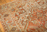 Distressed Mehrivan carpet with low pile, geometric blossoms, and serrated leaves in terracotta, ivory, and silver tones.
