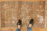 Distressed Karaja rug detail with central hooked medallion, geometric florals, rust, blue hues.