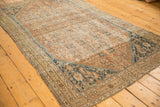 Antique Shiraz rug detail: intricate dark navy corner, pale copper Herati field, foundation visible.