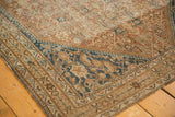 Edge of antique Shiraz rug featuring pale copper Herati and dark navy border.