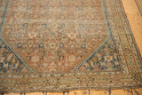 Antique Shiraz rug corner, showcasing worn Herati motif, copper and navy tones, visible foundation.