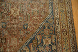 Intricate Herati motif on an antique Persian Shiraz rug corner, showing aged texture in copper, navy, and green.