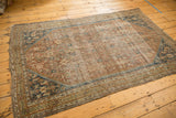 Worn pale copper Herati motif field with dark navy spandrel and detailed borders on a Shiraz rug.