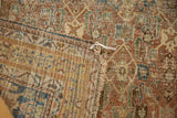Folded antique Shiraz rug with worn Herati pattern, exposed foundation, and tattered edge.