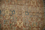 Antique Shiraz rug's threadbare pile, visible foundation, small holes, pale copper, navy, green Herati motifs.