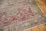 Distressed raspberry red field, exposed foundation, and dusty slate green border of Sivas rug.
