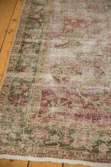 Distressed vintage Sivas rug, with exposed foundation and faded raspberry, green floral motifs.
