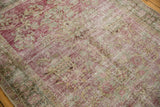 Distressed Sivas rug showing exposed foundation and knot heads amidst faded red and green florals.