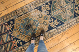 Antique Northwest Persian runner's geometric patterns with prominent wear, navy, beige, sky blue tones.