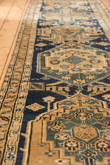 Antique Northwest Persian runner's geometric motifs in time-softened navy, dark mallard green, and sand.