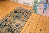 Antique Northwest Persian runner's geometric field, intricate border, and textural wear in navy, sand, sky blue.