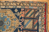 Antique Northwest Persian runner corner: navy, sand, red geometric patterns with exposed foundation.