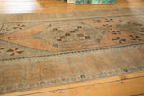 Interconnected medallion and pinwheel motifs on a distressed Oushak rug in apricot peach and silver.