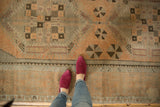 Distressed Oushak runner with low pile texture, apricot peach field, and pinwheel motifs.
