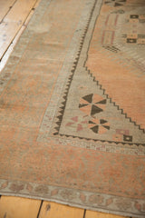 Distressed Oushak rug detail: charcoal pinwheel spandrel, apricot floral border, low pile.
