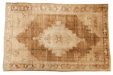 Vintage distressed Oushak carpet with abrashed field, oversized medallion, ivory and bronze tones.