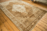 Distressed Oushak rug, showing abrashed texture and primitive stepped medallion.