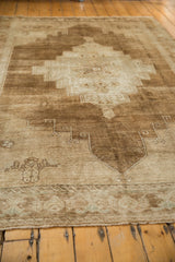 Detail of the primitive border design and distressed low pile in sand and bronze.