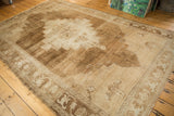 Heavily abrashed field of distressed vintage Oushak carpet with primitive motifs.