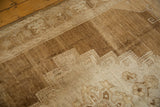 Abrashed vintage Oushak carpet featuring primitive stepped medallion design in bronze and ivory.