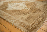 Distressed texture with primitive motifs on the abrashed bronze Oushak rug border.