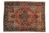 Vintage Heriz carpet with a bold central medallion, geometric florals, cherry red, navy blue.