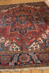 Hand-knotted fringe and a rich navy blue, brick red, ivory geometric border on a vintage Heriz carpet.