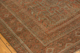 Intricate multi-stripe borders and serrated plant motifs of the Belouch carpet in madder root red.