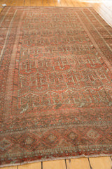 Vintage Belouch carpet: intricate multi-stripe border, madder red and silver tones, with fringe.