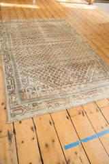 Distressed Mir Serbend rug corner, showing fine fringe, mir boteh, and blue, orange border motifs.