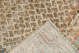 Distressed vintage Mir Serbend rug corner displaying worn beige pile, secured fringe, and hand-knotted foundation.