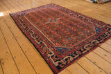 Vintage cherry red Malayer rug showing allover Herati motif, blue borders, and central diamond finials.