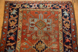 Abrashed madder red Karaja field with stepped geometric blue medallion, showing knot head wear.