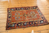 Vintage Karaja square rug with concentric geometric medallions and visible pile wear on the red field.