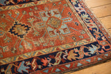 Geometric Karaja rug corner with a navy border, sky blue blossoms, and abrash.