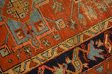 Abrashed madder red field, navy blue border, and geometric motifs on vintage Karaja rug.