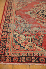 Cherry red field of vintage Mahal rug with navy border, floral motifs, and visible wear.