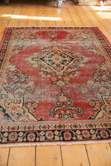 Navy floral border and cherry red field with even wear, ivory fringe.