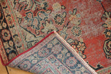 Vintage hand knotted Mahal rug corner, showing worn cherry red pile, navy foundation, and fringe.