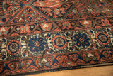 Vintage Baktiari carpet detail: madder red, cobalt blue floral border, secured edge.