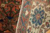 Vintage Baktiari carpet detail: worn madder red pile, garden motif, and hand-knotted reverse.
