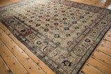 Angled perspective of a distressed Veramin carpet with a classic floral field and Herati border.